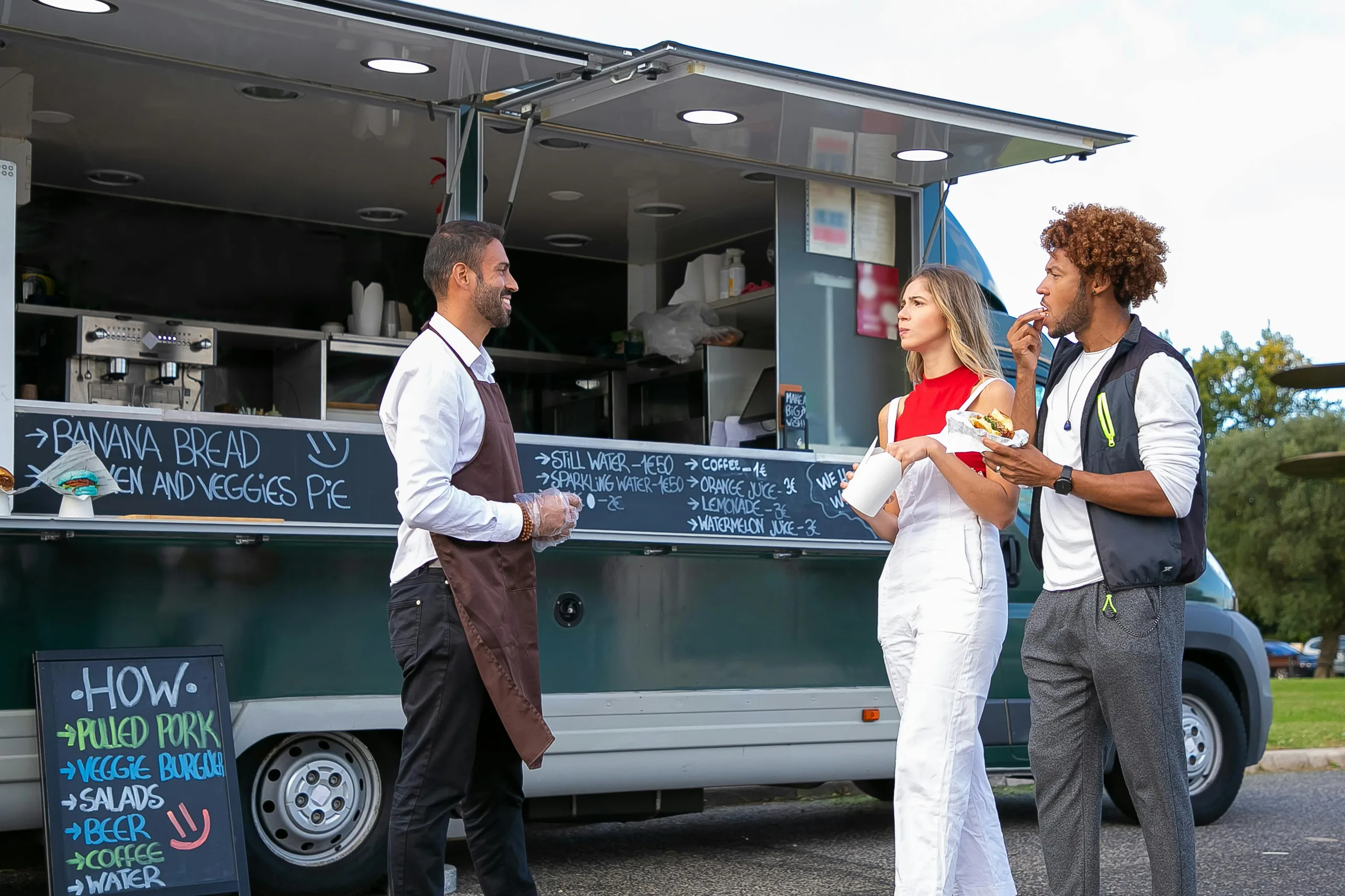 Photo by Kampus Production: https://www.pexels.com/photo/young-multiracial-couple-eating-takeaway-fast-food-and-walking-near-ethnic-chef-standing-near-van-5920734/